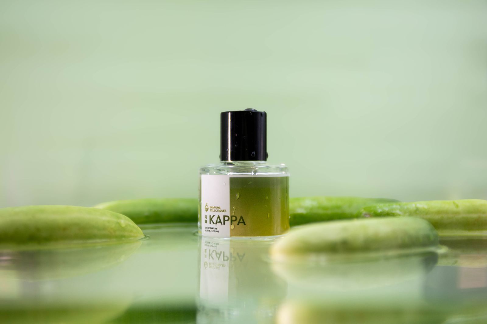 Kappa eau de parfum standing in shallow water between cucumbers